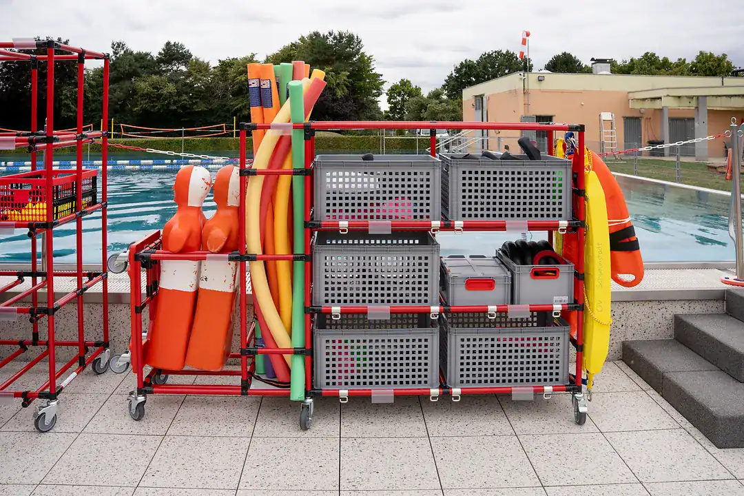 Poolnudeln und Gurtretter auf dem mobilen 5S Materialwagen direkt am Beckenrand