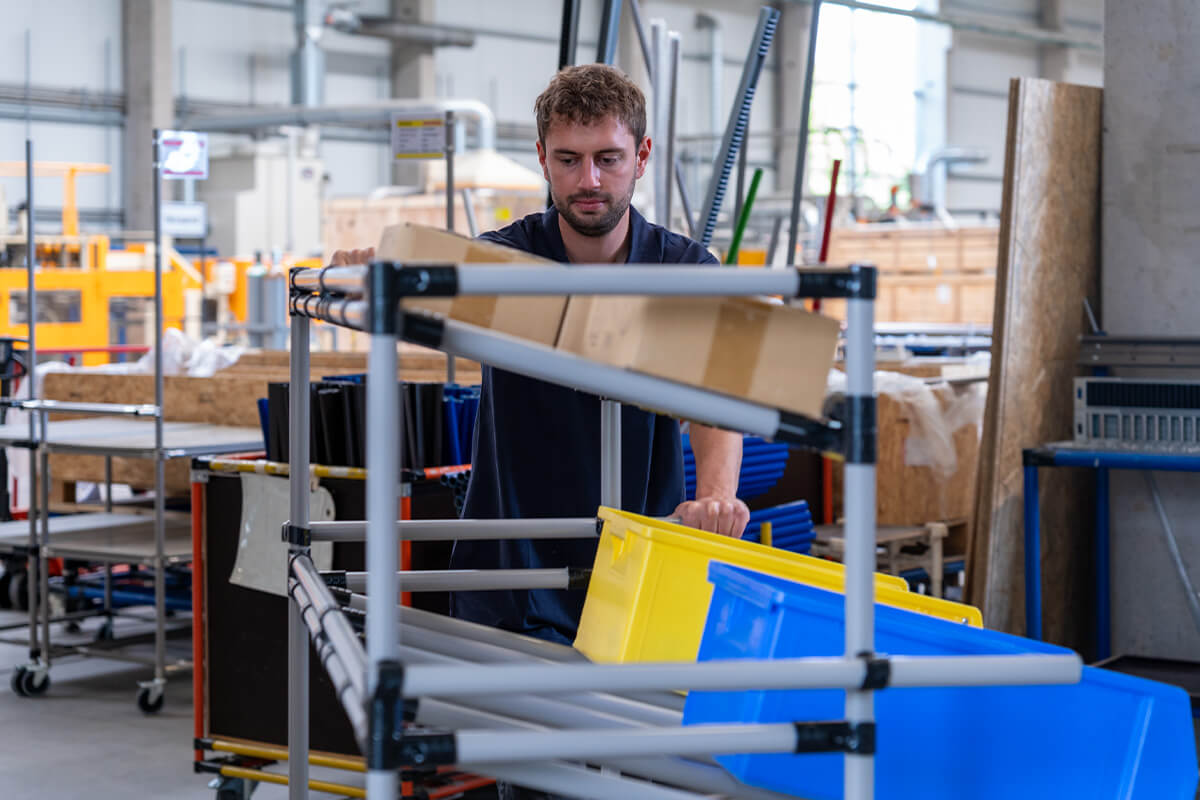 Schieben eines Materialwagens mit Rollen